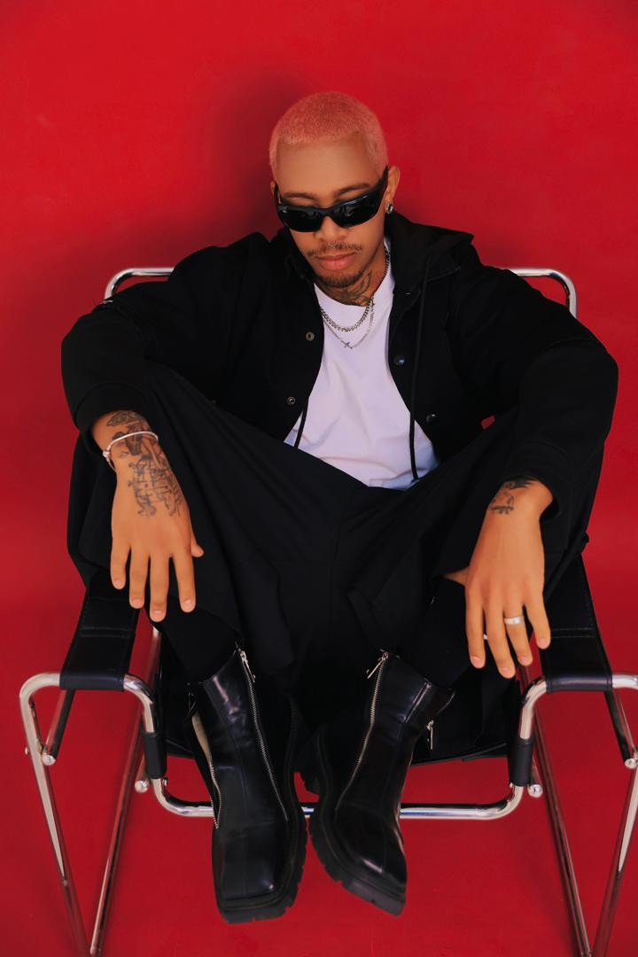 Osmar seated in a chair, dressed in black